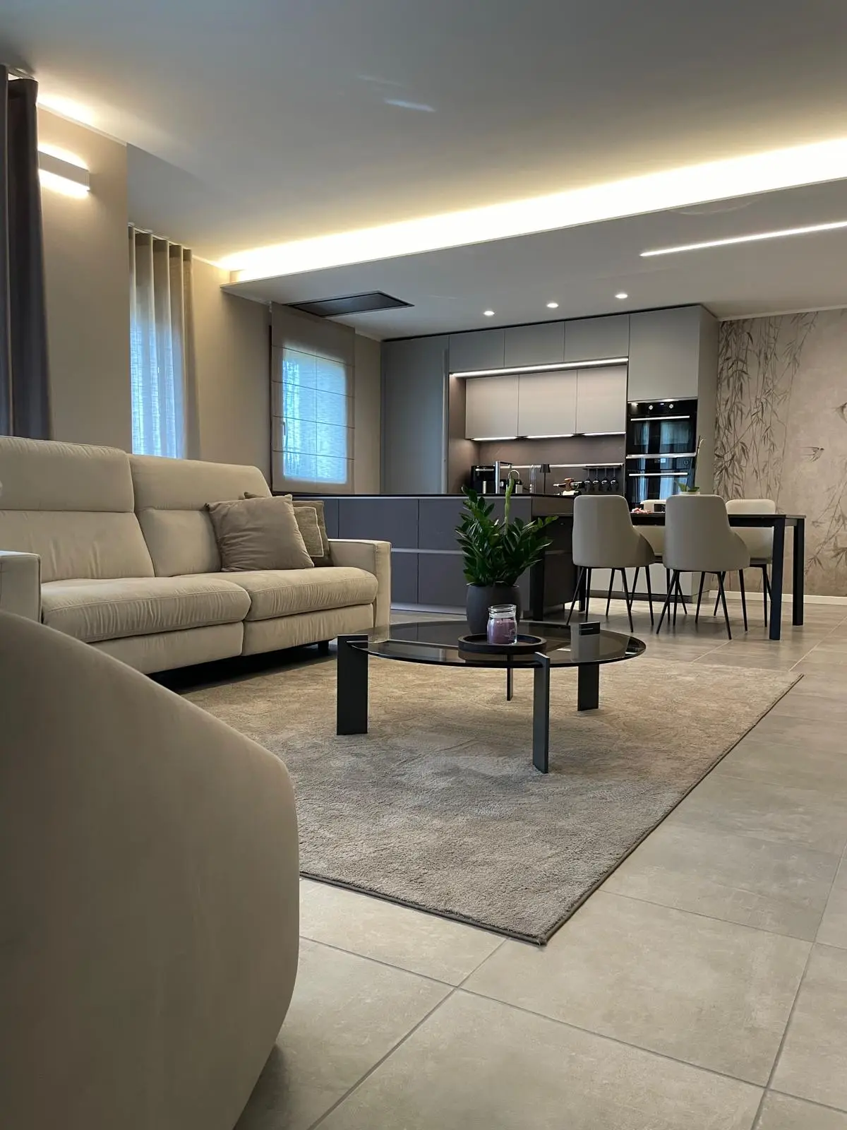 Vista della zona living integrata con la cucina progettata per garantire continuità estetica e funzionale.