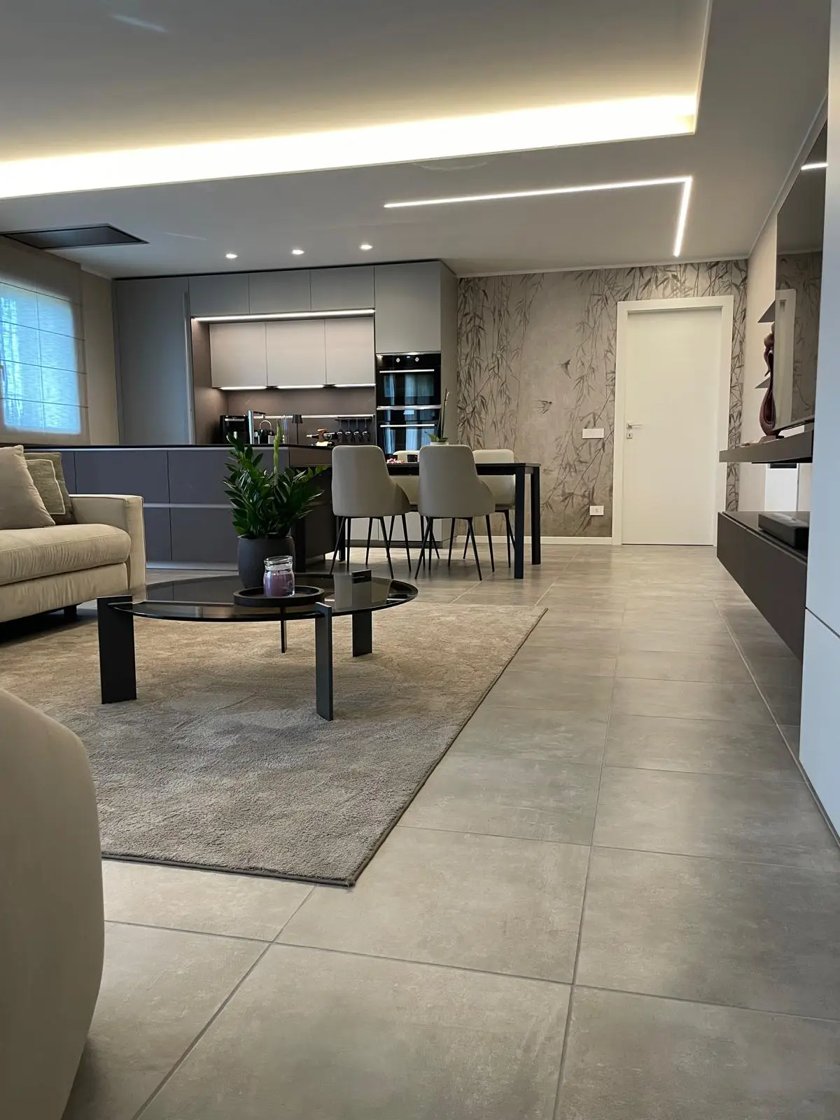 Ambiente open space ultimato con cucina moderna, soggiorno e zona pranzo realizzati seguendo il progetto sviluppato da Suardi.